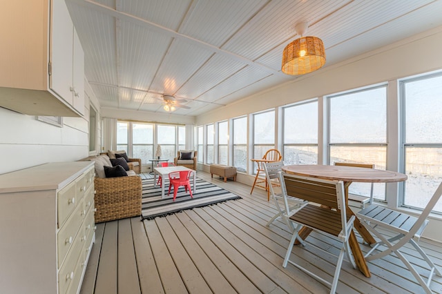 sunroom / solarium featuring ceiling fan, a water view, and a wealth of natural light