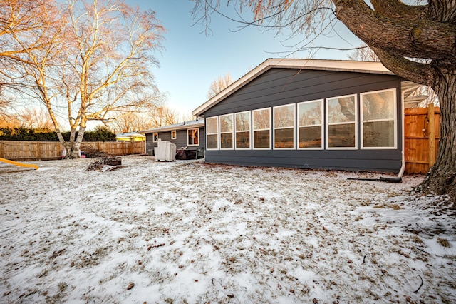 snow covered property featuring a sunroom