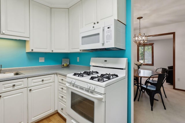 kitchen with a notable chandelier, decorative light fixtures, white cabinets, and white appliances