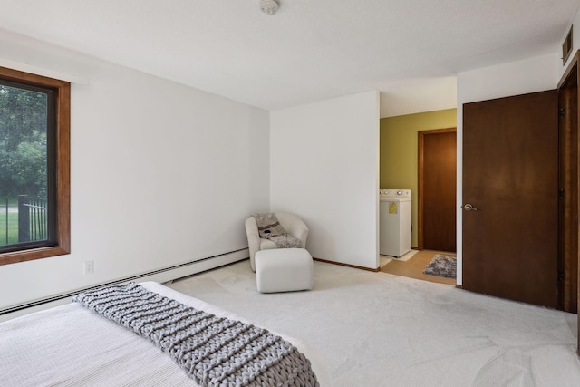 carpeted bedroom featuring a textured ceiling, washer / clothes dryer, and a baseboard radiator