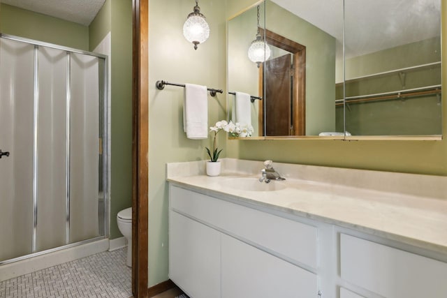 bathroom with tile patterned floors, a textured ceiling, an enclosed shower, toilet, and vanity