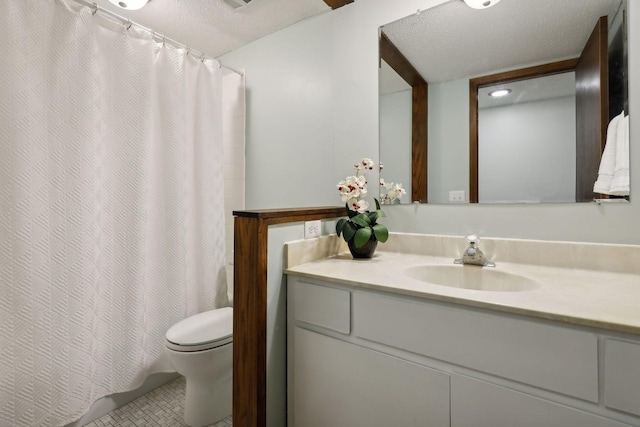 bathroom featuring tile patterned flooring, vanity, a textured ceiling, and toilet