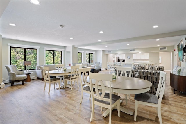 dining space with a textured ceiling and light wood-type flooring