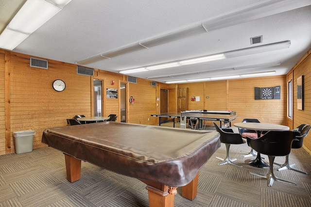 rec room with carpet flooring, a textured ceiling, billiards, and wood walls