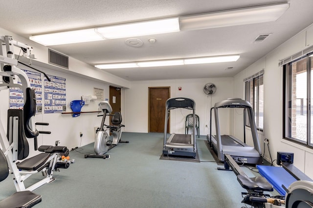 exercise room with carpet and a textured ceiling