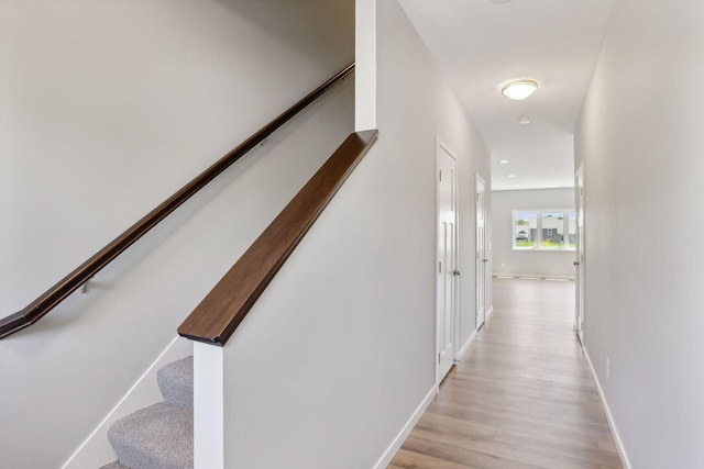 stairway with light hardwood / wood-style floors