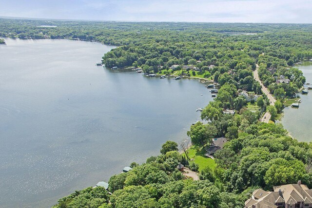drone / aerial view featuring a forest view and a water view