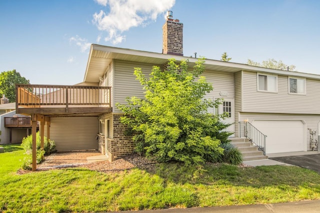 exterior space with a garage, a front yard, and a wooden deck