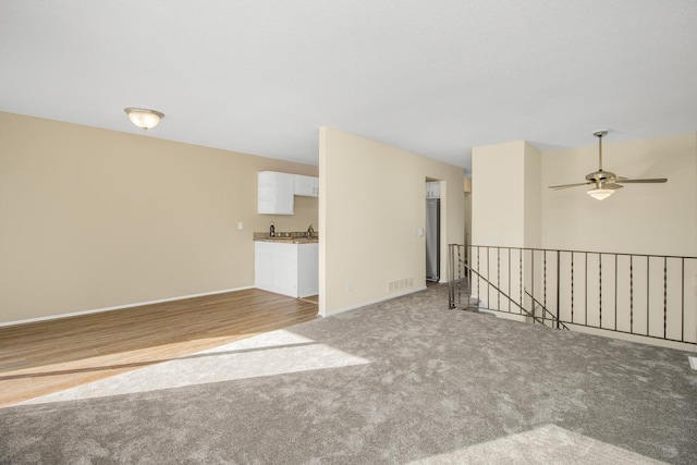 spare room with ceiling fan and light colored carpet