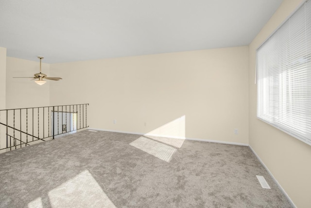 carpeted spare room with ceiling fan