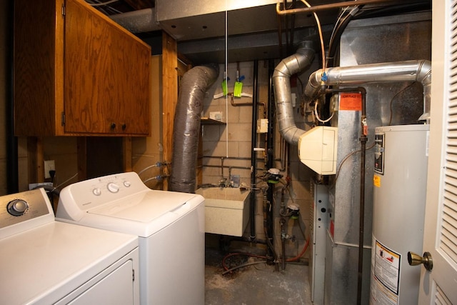 laundry area with gas water heater, sink, and washing machine and dryer