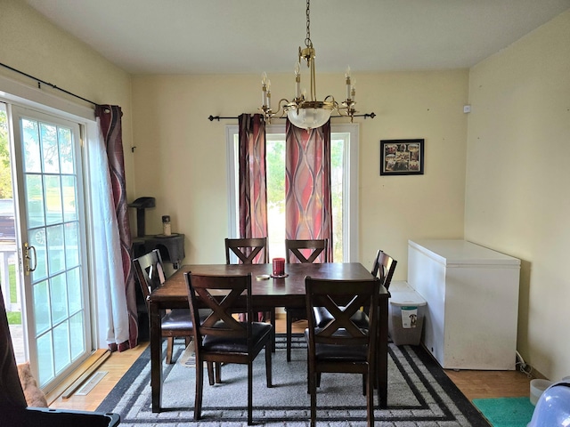 dining room with a wealth of natural light, hardwood / wood-style flooring, and an inviting chandelier