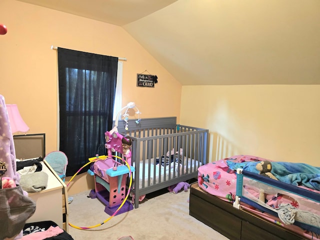 bedroom featuring lofted ceiling, carpet, and a crib