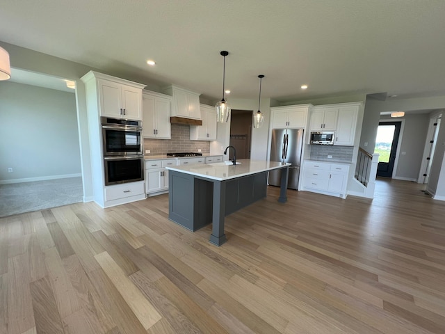 kitchen with white cabinetry, stainless steel appliances, and decorative light fixtures