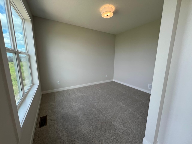 spare room with dark carpet