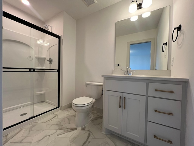 bathroom featuring vanity, a shower with shower door, and toilet