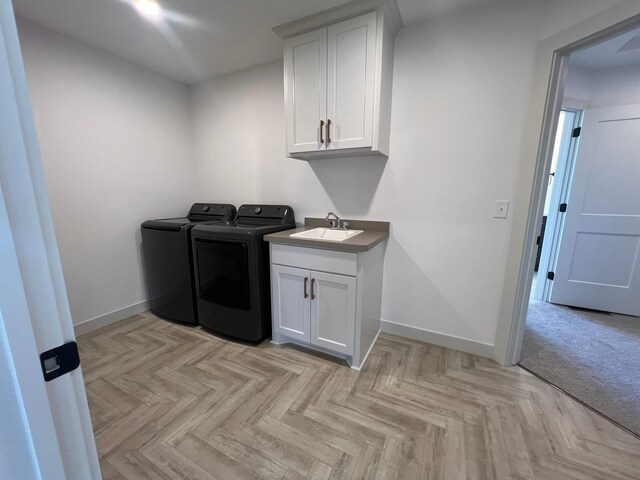 laundry room with baseboards, a sink, independent washer and dryer, and cabinet space
