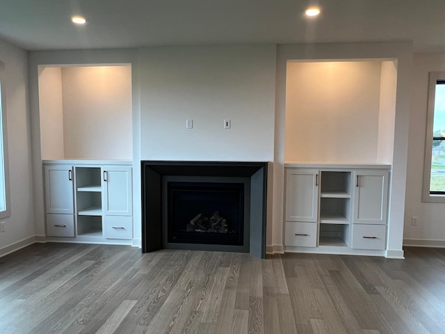 unfurnished living room with a fireplace, baseboards, wood finished floors, and recessed lighting