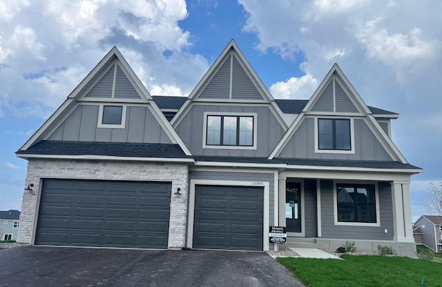 11088 Kingsview Ln N, Dayton, MN 55369 - view of front of property with board and batten siding, covered porch, asphalt driveway, and an attached garage