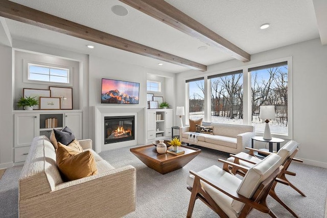 interior space with a healthy amount of sunlight, beamed ceiling, and a textured ceiling