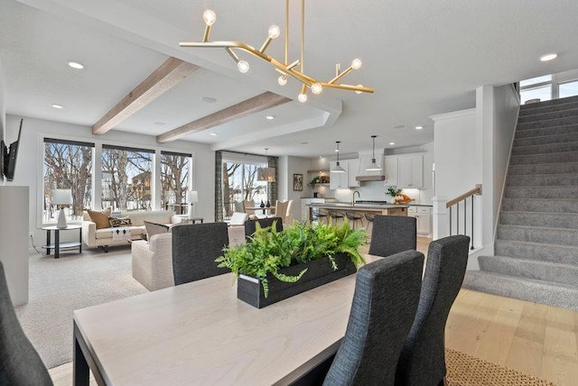 dining room featuring a notable chandelier, beamed ceiling, stairway, and recessed lighting