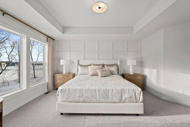 bedroom featuring carpet, a raised ceiling, visible vents, and baseboards