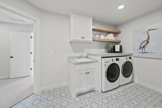 laundry area with washer and clothes dryer, recessed lighting, cabinet space, a sink, and baseboards