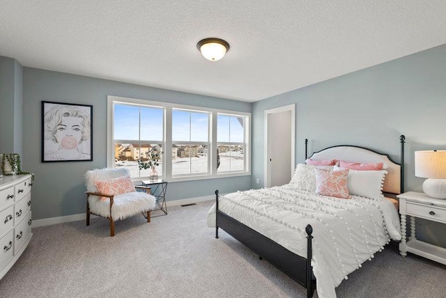 bedroom featuring baseboards, a textured ceiling, and light colored carpet