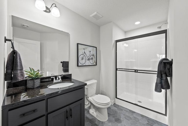 full bath featuring visible vents, toilet, a textured ceiling, vanity, and a shower stall