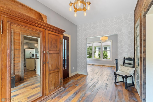 sitting room with hardwood / wood-style floors and a notable chandelier