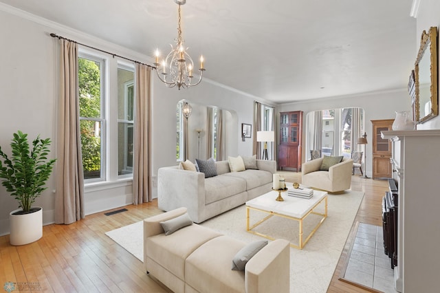 living room featuring crown molding, a healthy amount of sunlight, and light wood-type flooring