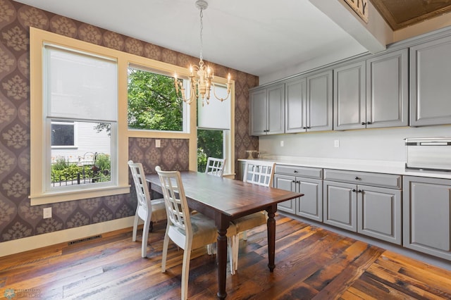 dining room featuring an inviting chandelier, dark hardwood / wood-style flooring, and a wealth of natural light