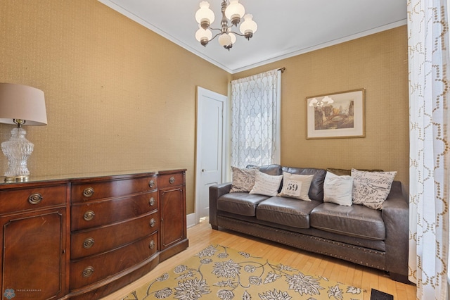 living room with crown molding, a notable chandelier, and light hardwood / wood-style flooring