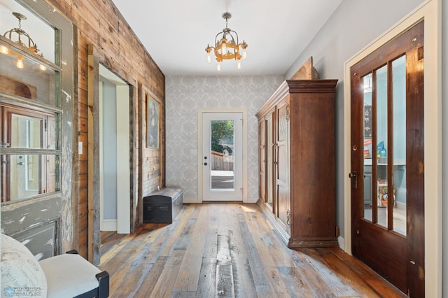 corridor with a notable chandelier and light hardwood / wood-style floors