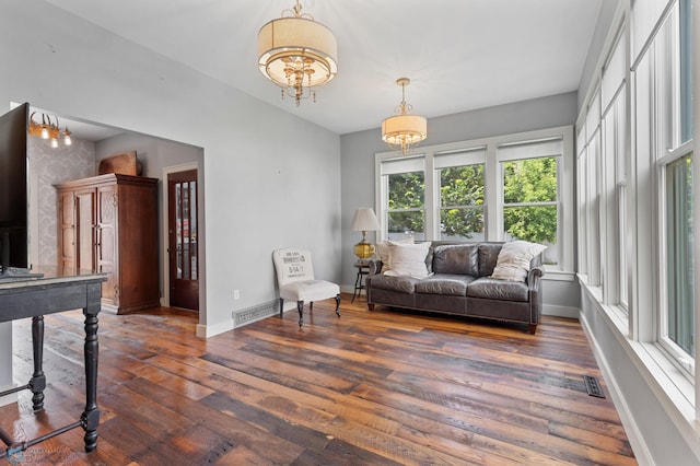 living room featuring an inviting chandelier and dark wood-type flooring