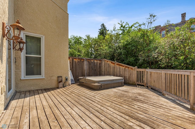 deck featuring a covered hot tub