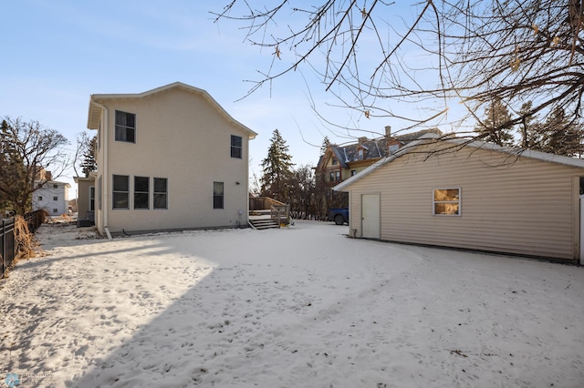 view of snow covered back of property