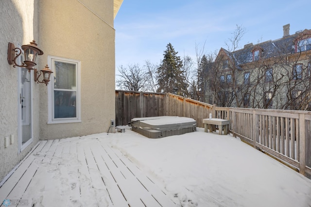 snow covered deck featuring a covered hot tub