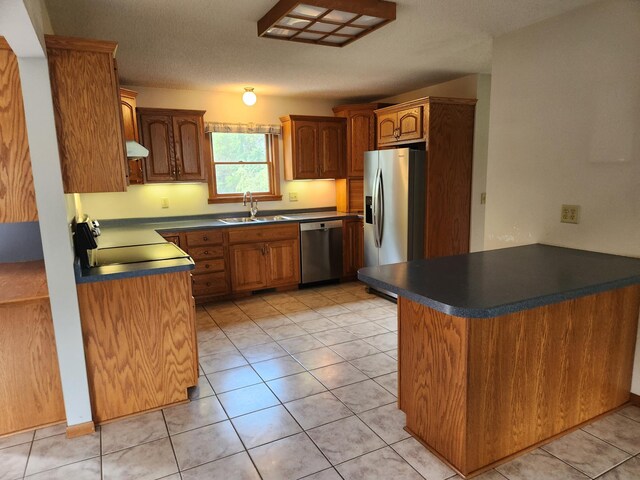 kitchen featuring stainless steel appliances, kitchen peninsula, light tile patterned floors, and sink