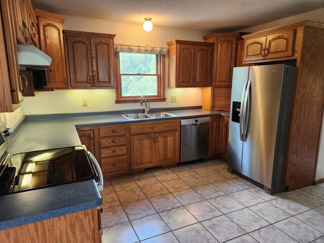 kitchen featuring light tile patterned floors, stainless steel appliances, a textured ceiling, sink, and extractor fan