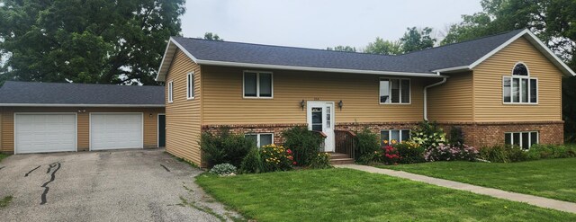 split foyer home featuring a garage and a front lawn