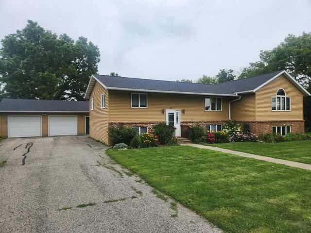 raised ranch with a garage and a front lawn