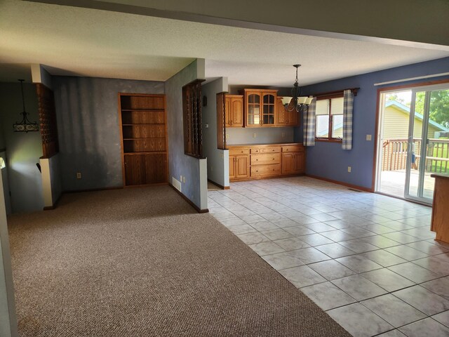 unfurnished living room with an inviting chandelier, a textured ceiling, and light tile patterned floors