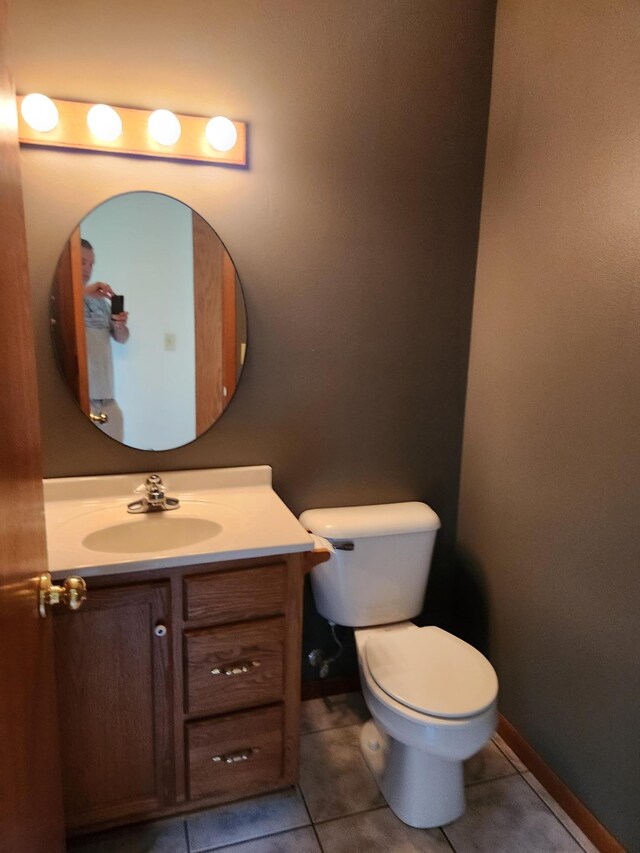 bathroom featuring vanity, tile patterned flooring, and toilet