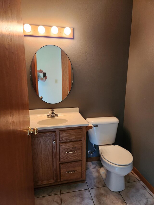 bathroom with tile patterned flooring, vanity, and toilet