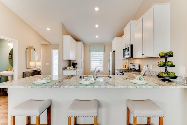 kitchen with stainless steel appliances, a kitchen bar, and kitchen peninsula