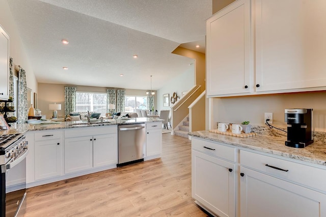 kitchen with sink, light hardwood / wood-style flooring, stainless steel appliances, and white cabinets