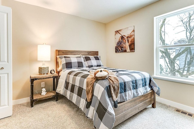 carpeted bedroom with visible vents and baseboards