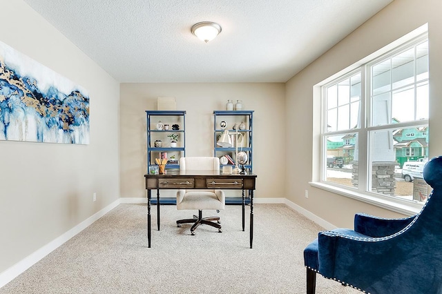 carpeted office featuring a textured ceiling and baseboards