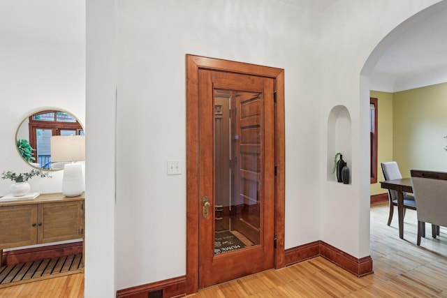 2410 Irving Ave S, Minneapolis, MN 55405 - corridor featuring arched walkways, light wood-style floors, and baseboards